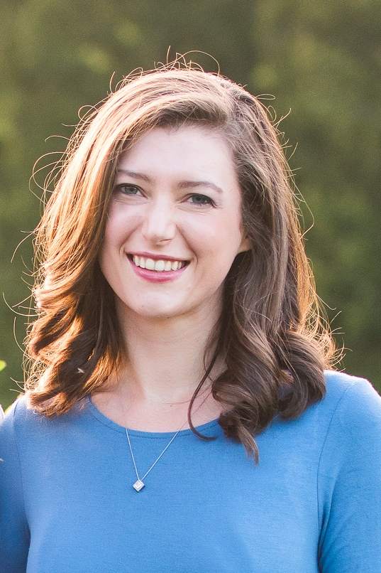 sunlit headshot of woman in a blue sweater